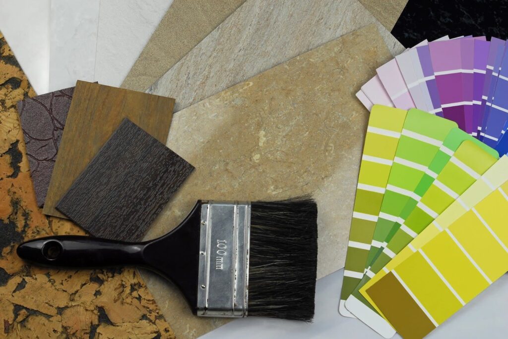 paint brush on a table with colour swatches and material samples