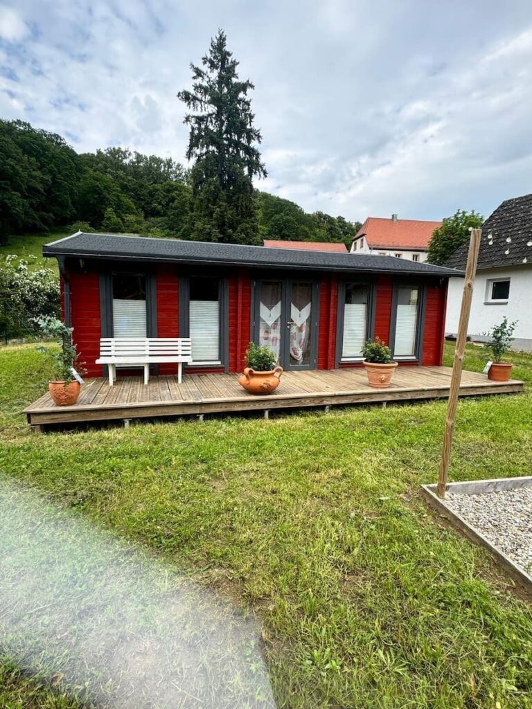 red coloured summerhouse with trim
