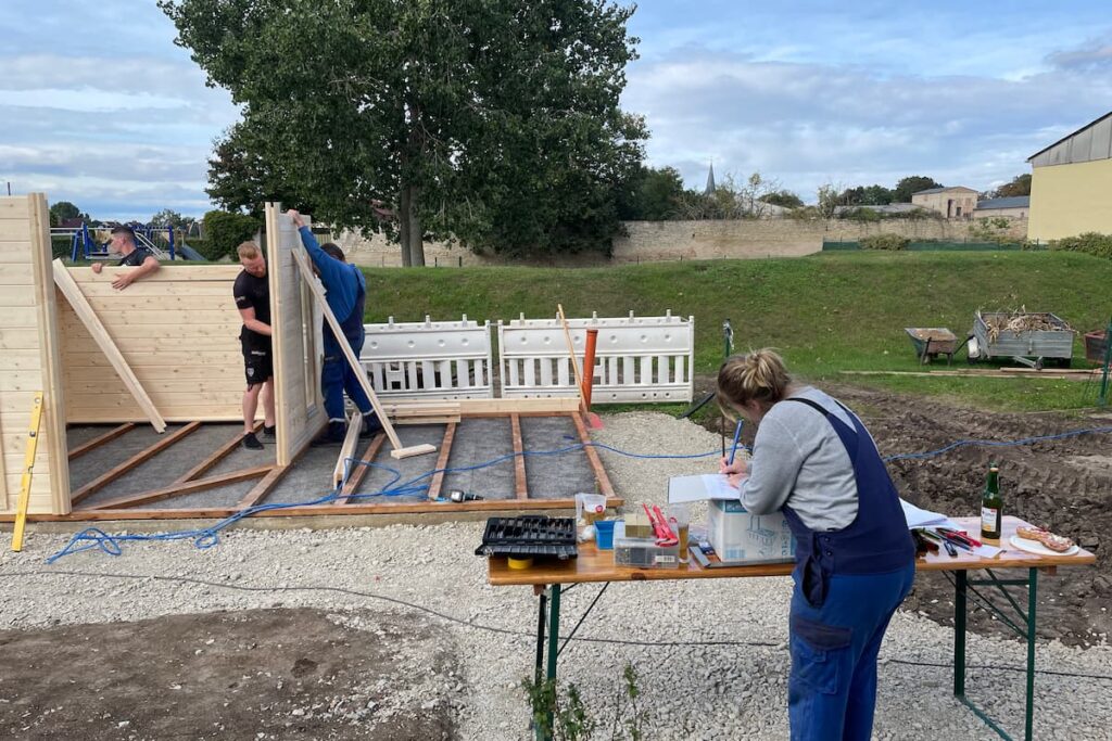 three people building a summer house